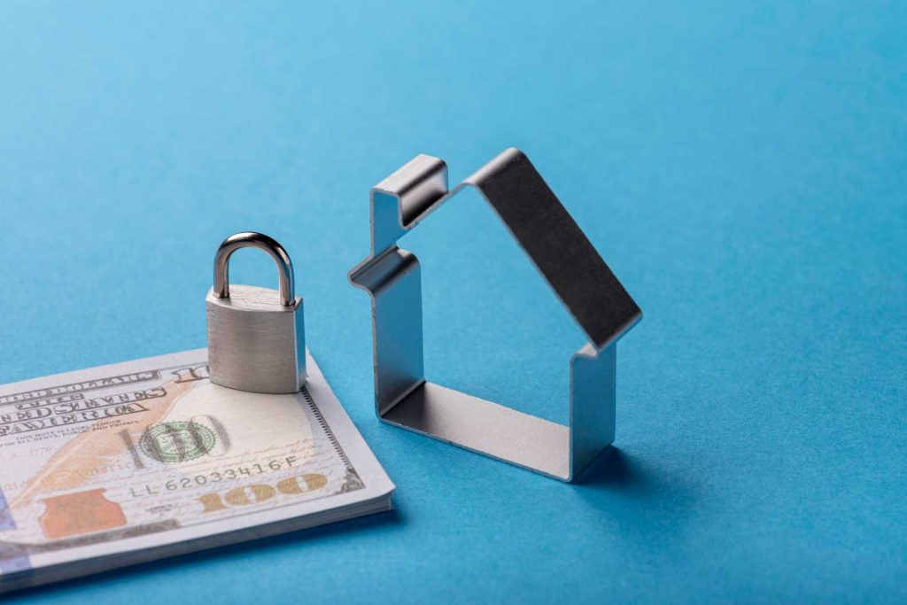 Metal house outline with padlock and dollar bills
